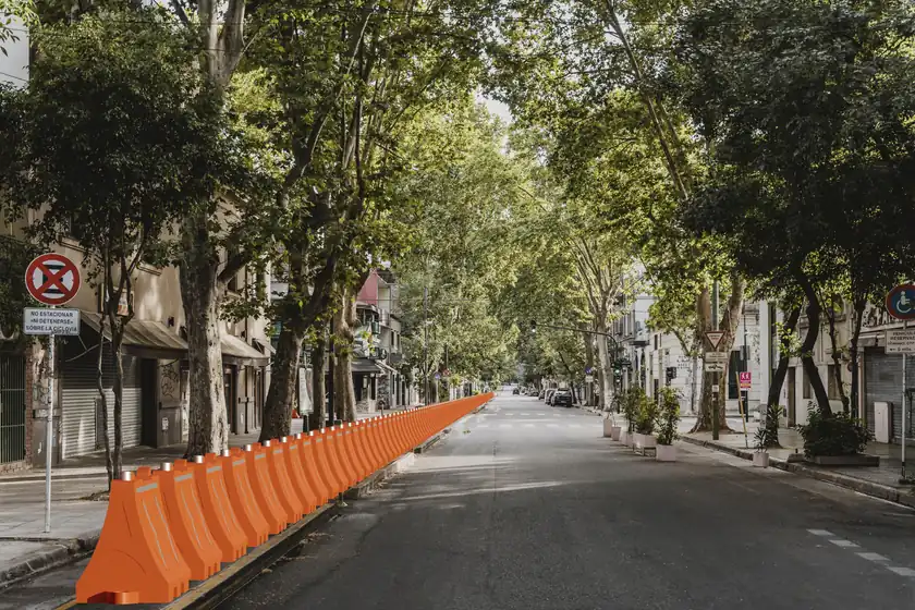 Render de una fila de Barreras Ray naranja delimitando una calle arbolada